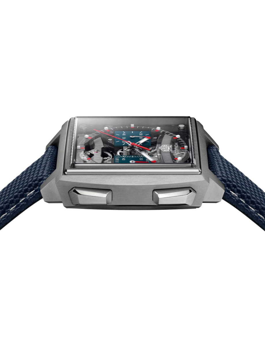 Side view of Tag Heuer Monaco Evergraph wristwatch with titanium case, transparent dial, and blue rubber strap.