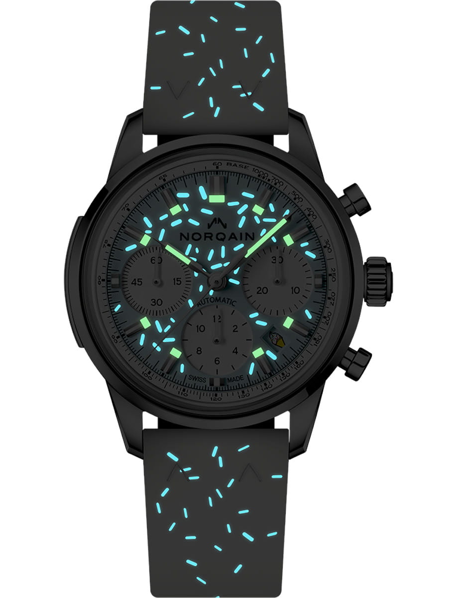 Night view of Norqain Sprinkles Blue Raspberry wristwatch with stainless steel case, light blue dial, and white rubber strap with glowing sprinkles.