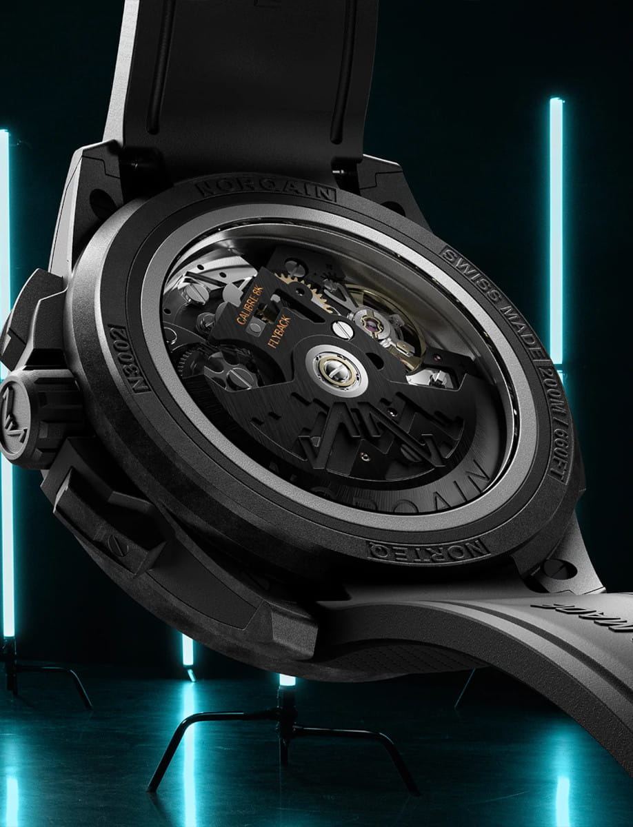 Back view of Norqain Wild ONE Skeleton Chrono wristwatch with NORTEQ titanium case, transparent case back, black rubber strap with “Milanese” pattern.