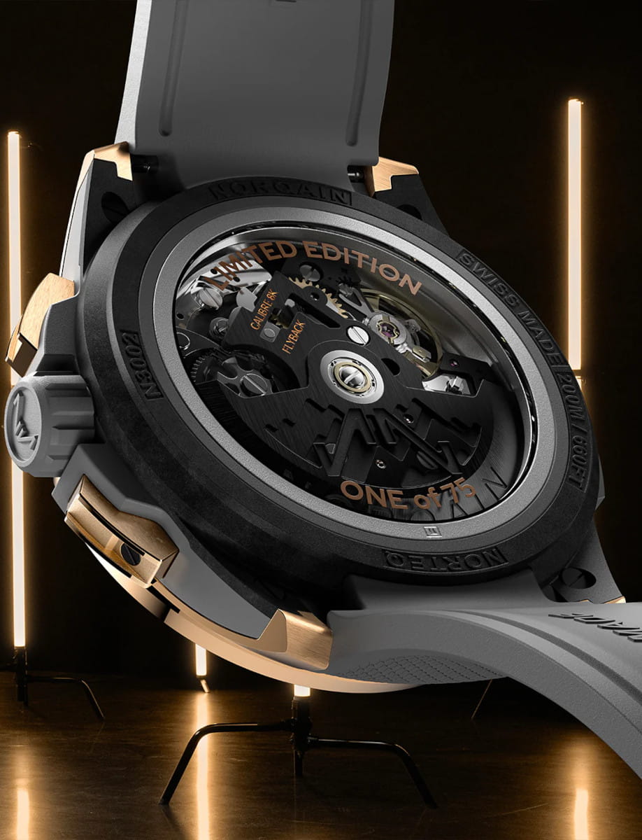 Back view of Norqain Wild ONE Skeleton Chrono Red Gold wristwatch with 18k 5N “PX IMPACT®” red case, open case back, grey rubber strap with “Milanese” pattern.