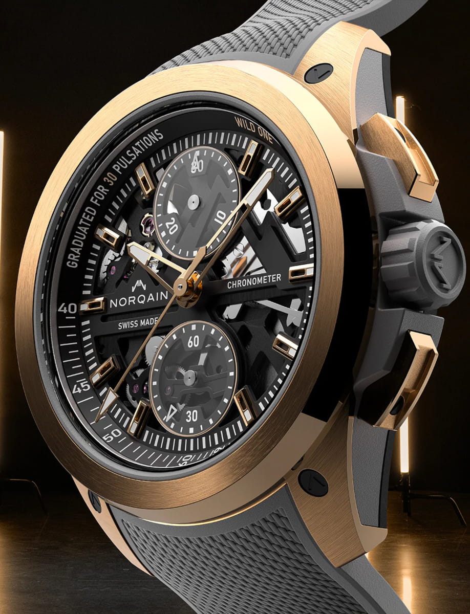 Side view of Norqain Wild ONE Skeleton Chrono Red Gold wristwatch with 18k 5N “PX IMPACT®” red case, black dial with white and gold printings, grey rubber strap with “Milanese” pattern.
