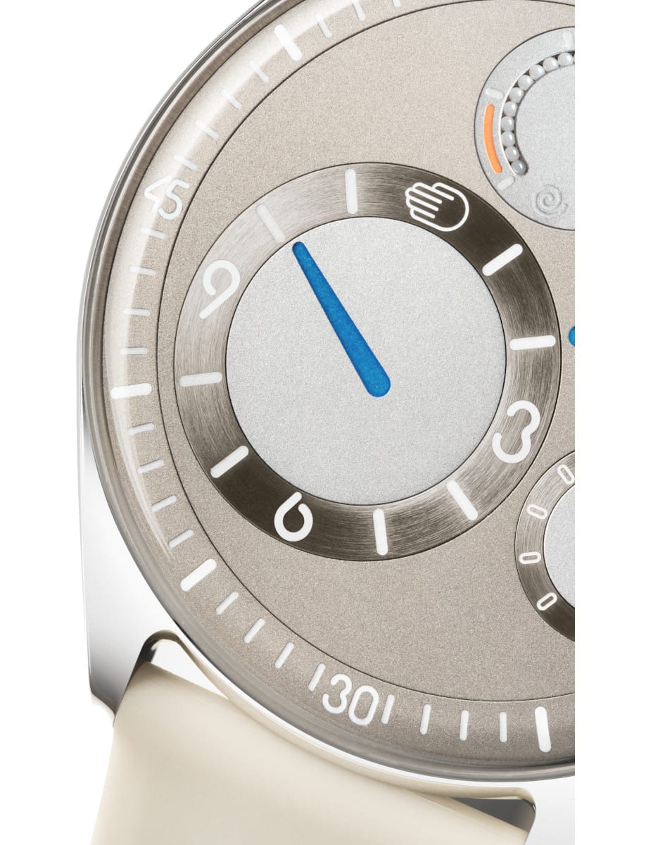 Close view of Ressence wristwatch with grade 5 titanium case, grey dial, and grey leather strap.