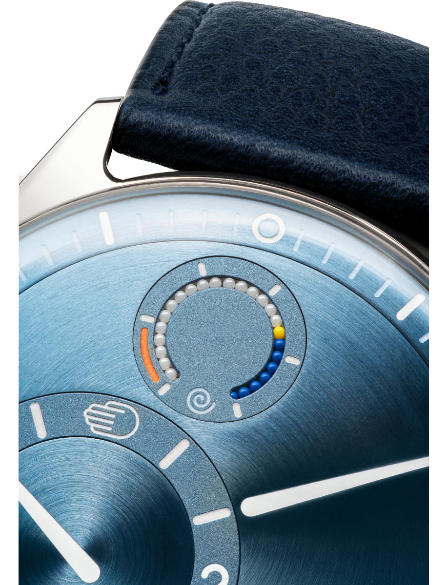 Close view of Ressence wristwatch with grade 5 titanium case, blue dial, and blue leather strap.