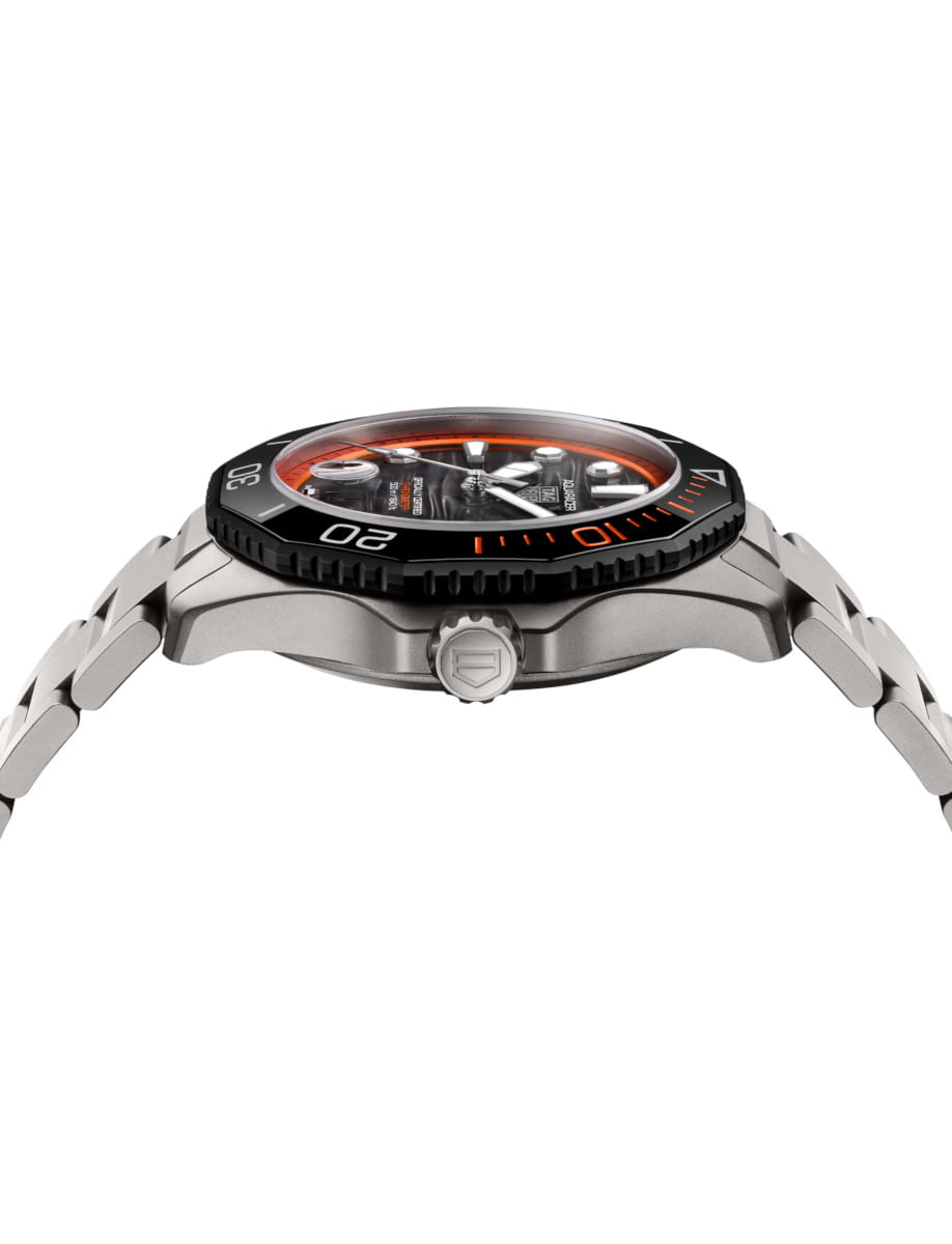 Side view of Tag Heuer Aquaracer Professional 500 Date wristwatch with titanium case and bracelet, and black and orange dial.