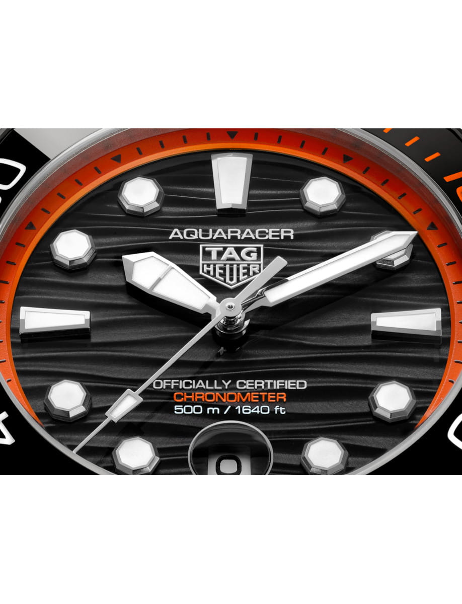 Close view of Tag Heuer Aquaracer Professional 500 Date wristwatch with titanium case and bracelet, and black and orange dial.