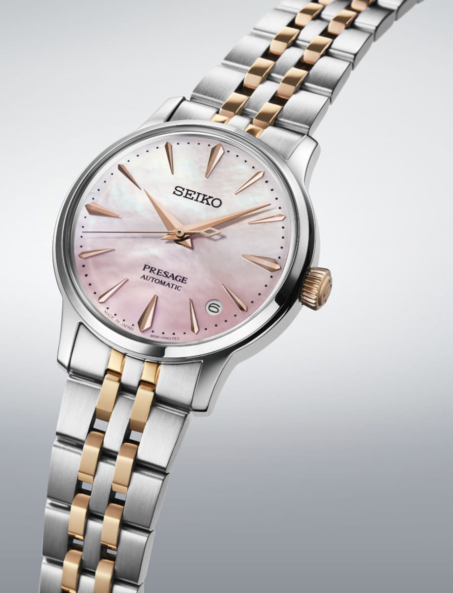 Side view of Seiko Presage Cocktail Time wristwatch with stainless steel case and bracelet, and pink mother of pearl dial.