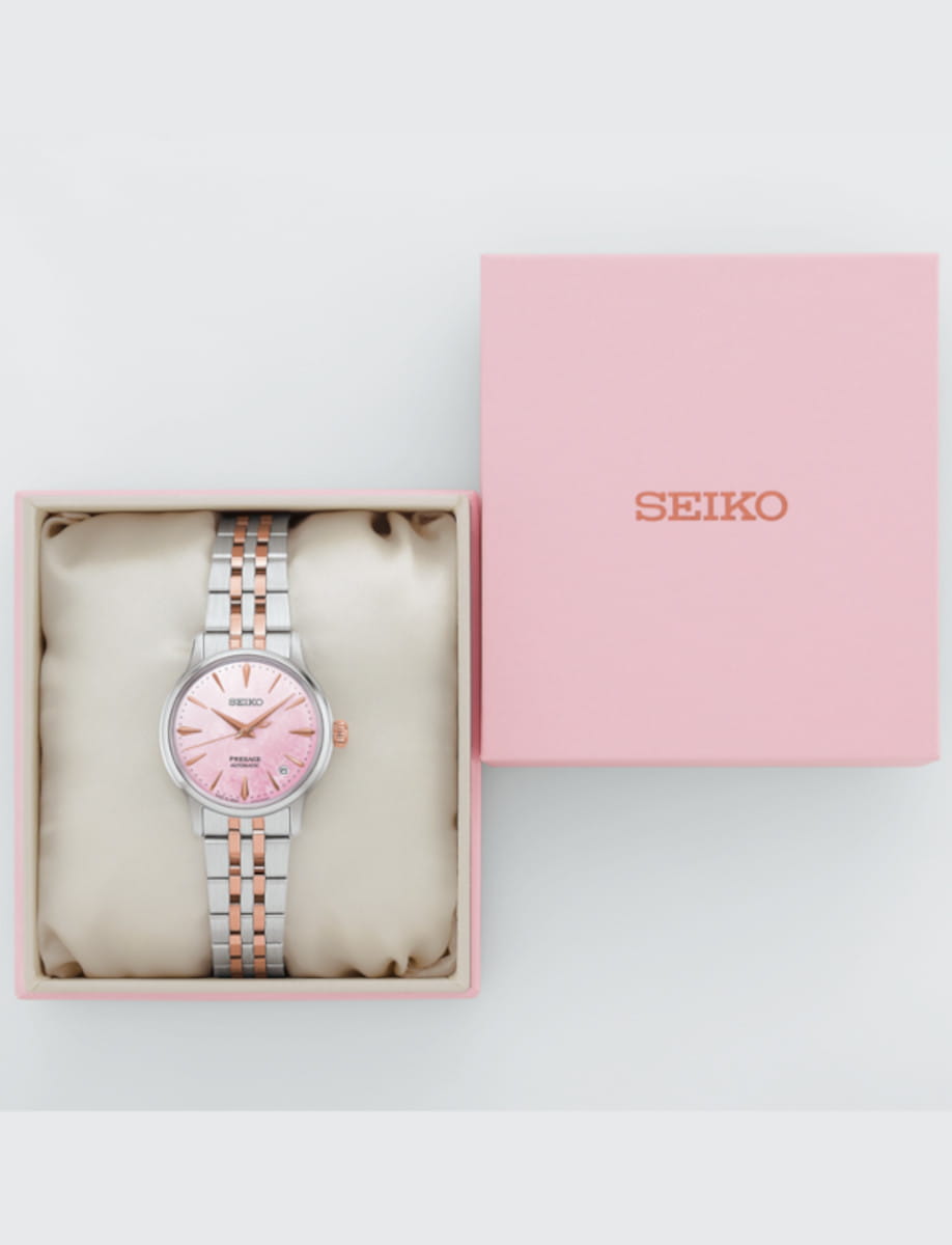 Box view of Seiko Presage Cocktail Time wristwatch with stainless steel case and bracelet, and pink mother of pearl dial.