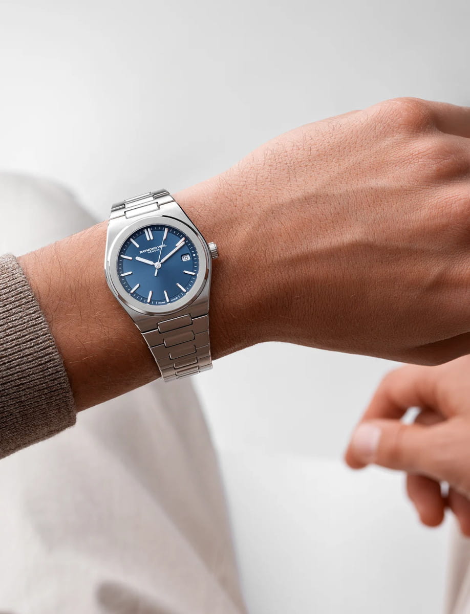 Lifestyle image of Raymond Weil A.R.T. wristwatch with stainless steel case and bracelet, and blue metallic dial.
