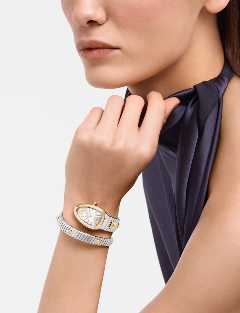 Lifestyle image of Bulgari Serpenti wristwatch with stainless steel and 18k yellow gold case and bracelet. and white mother-of-pearl dial.