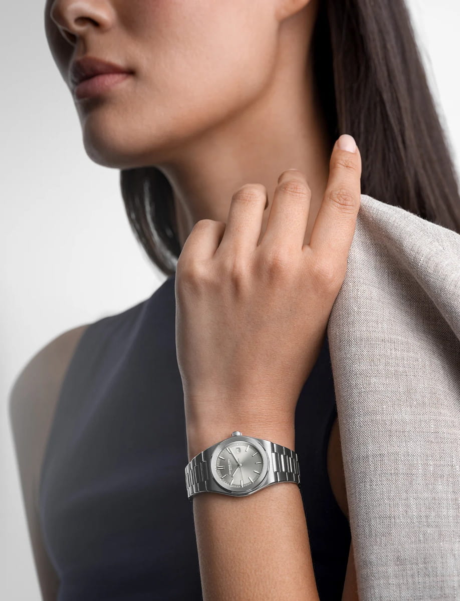 Lifestyle image of Raymond Weil A.R.T. wristwatch with stainless steel case and bracelet, and sage green dial.