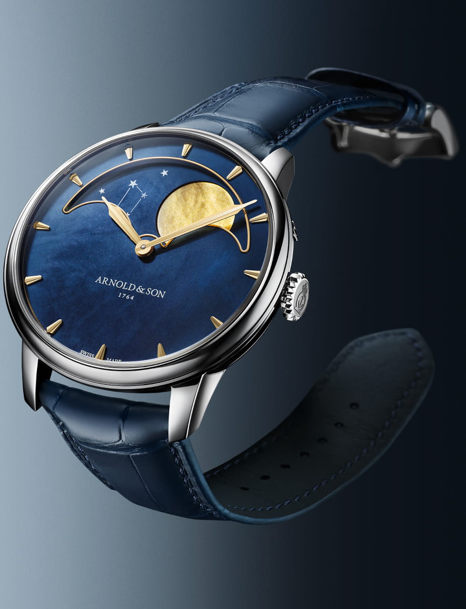 Side view of Arnold&Son Perpetual Moon wristwatch with stainless steel case, blue dial, and blue alligator leather.