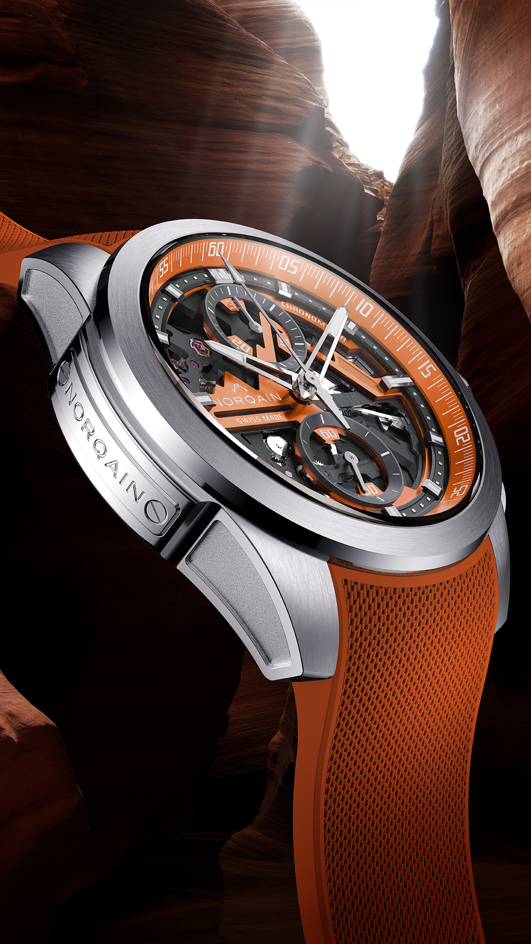 NORQAIN_Independence_Skeleton_Chrono_Orange_1080x1920_2 | Feldmar Watch Co. Skeleton-dial chronograph watch with orange accents and a textured orange strap, close-up view of the timepiece's inner mechanics and brushed metal case.