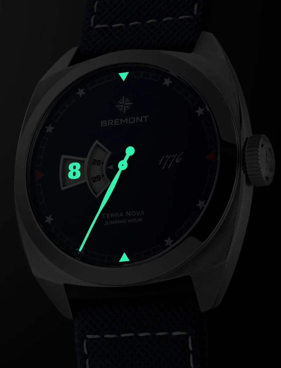 Night view of Bremont Terra Nova 40.5mm Jumping Hour 1776 wristwatch with stainless steel case and bracelet, and blue textured dial.