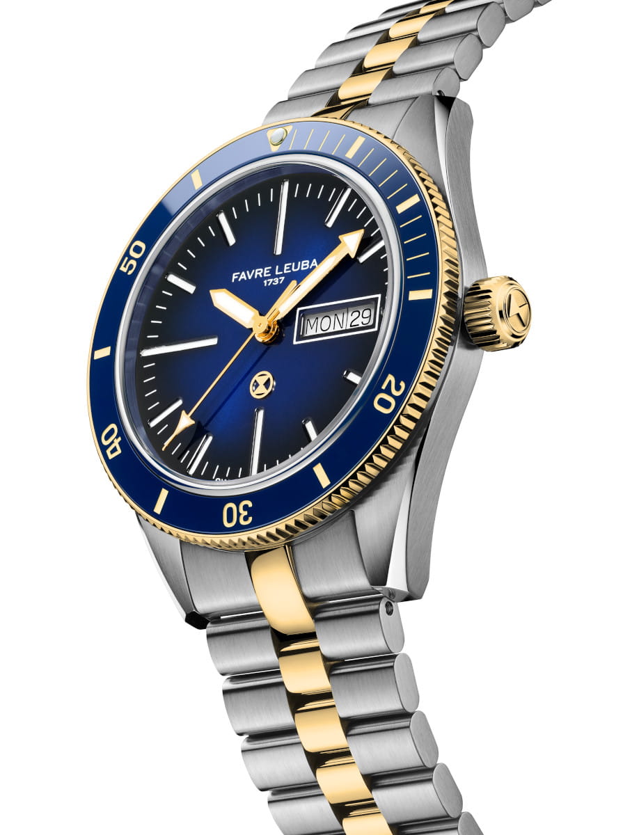 Two-tone stainless steel watch with a blue dial, gold bezel, and day-date window showing MON 29