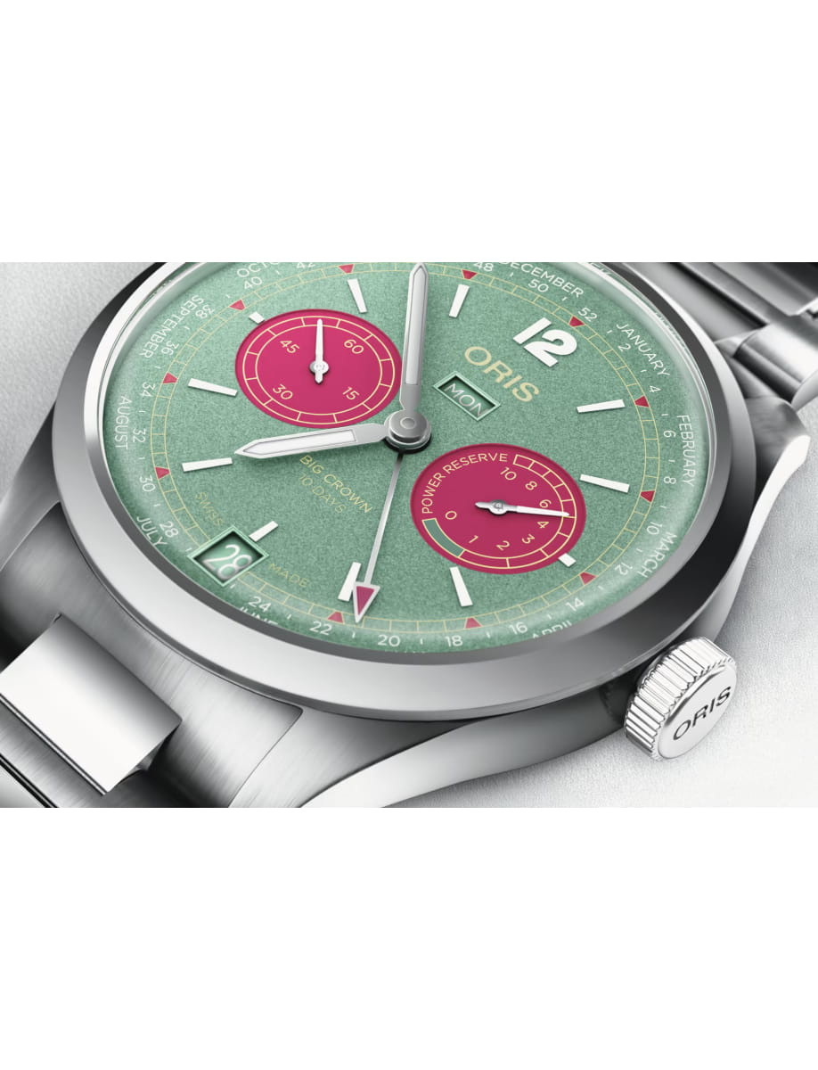 Close-up of an Oris stainless steel wristwatch with a green textured dial and red subdials with silver hands and markers.