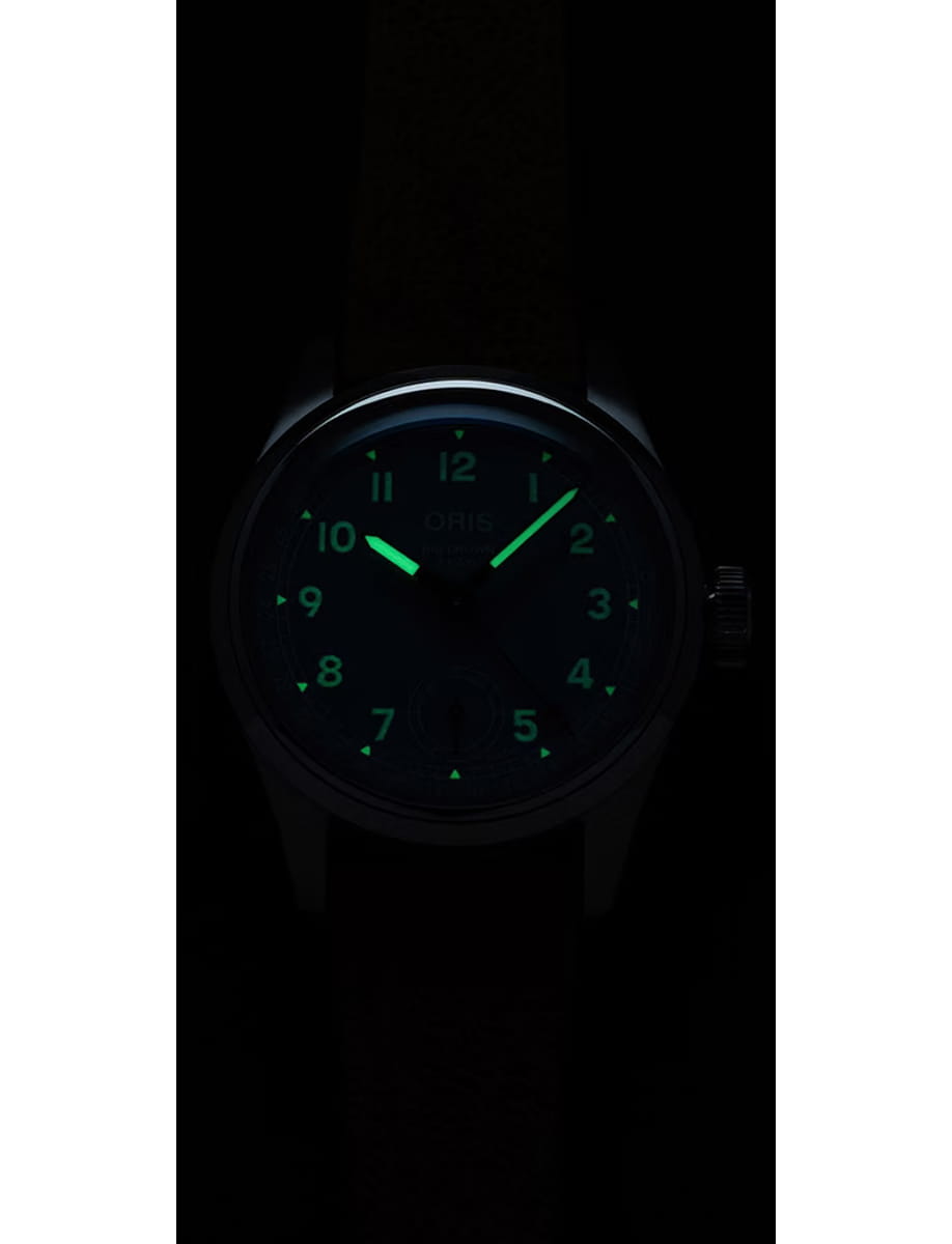 Wristwatch with a dark face and glowing green numerals and hands visible in the dark