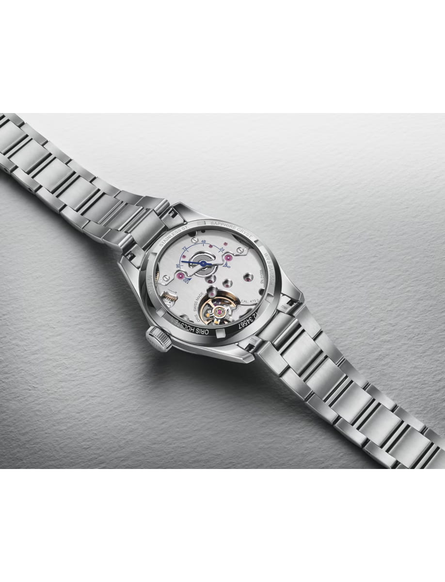 Stainless steel wristwatch with an open case back revealing its mechanical movement.