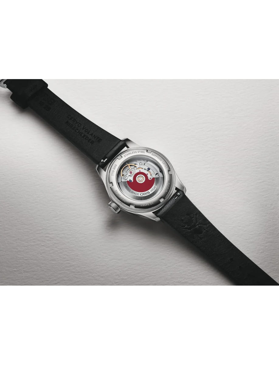 Wristwatch with a transparent back showing its mechanical movement and a black strap on a light surface.