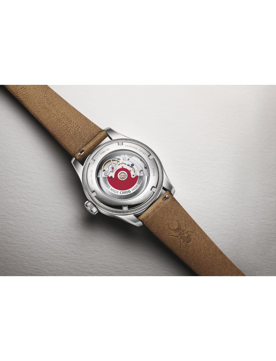 Stainless steel wristwatch with a transparent back showing the mechanical movement and a brown leather strap.