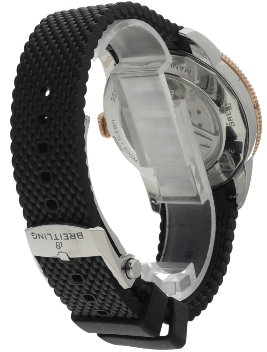 Back view of a black textured Breitling watch with a metal case and rubber strap, showcasing the clasp and case back.