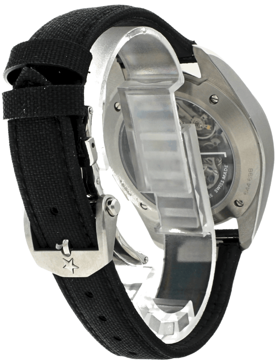 Back view of a stainless steel wristwatch with a black fabric strap and a transparent case back showing the movement gears.