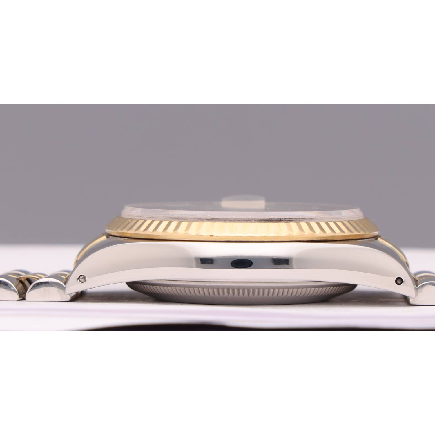 Close-up of a two-tone wristwatch focusing on the gold fluted bezel and metal bracelet