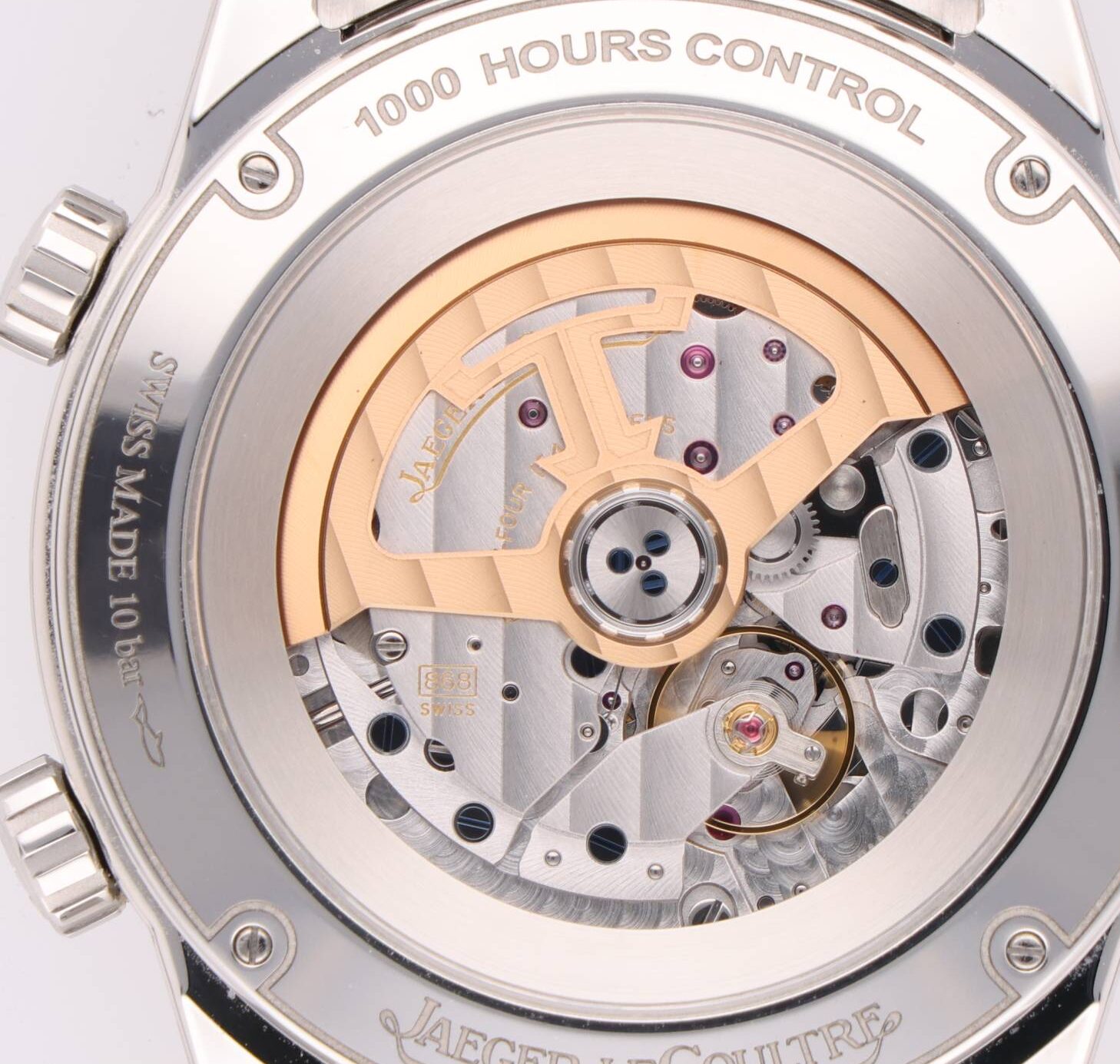 Close-up of a Jaeger-LeCoultre watch movement through the transparent case back, with a rose-gold rotor and visible gears.