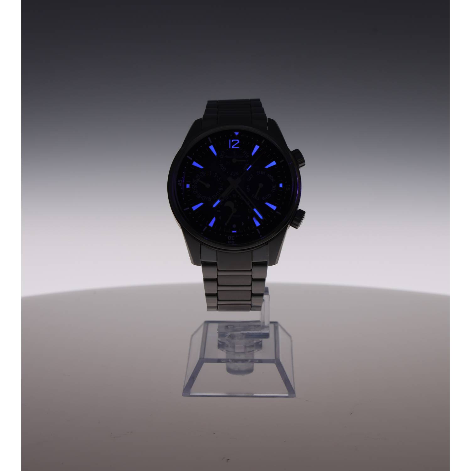 Black metal wristwatch with blue luminous markers on a round dial, displayed on a clear stand with a gray gradient background.