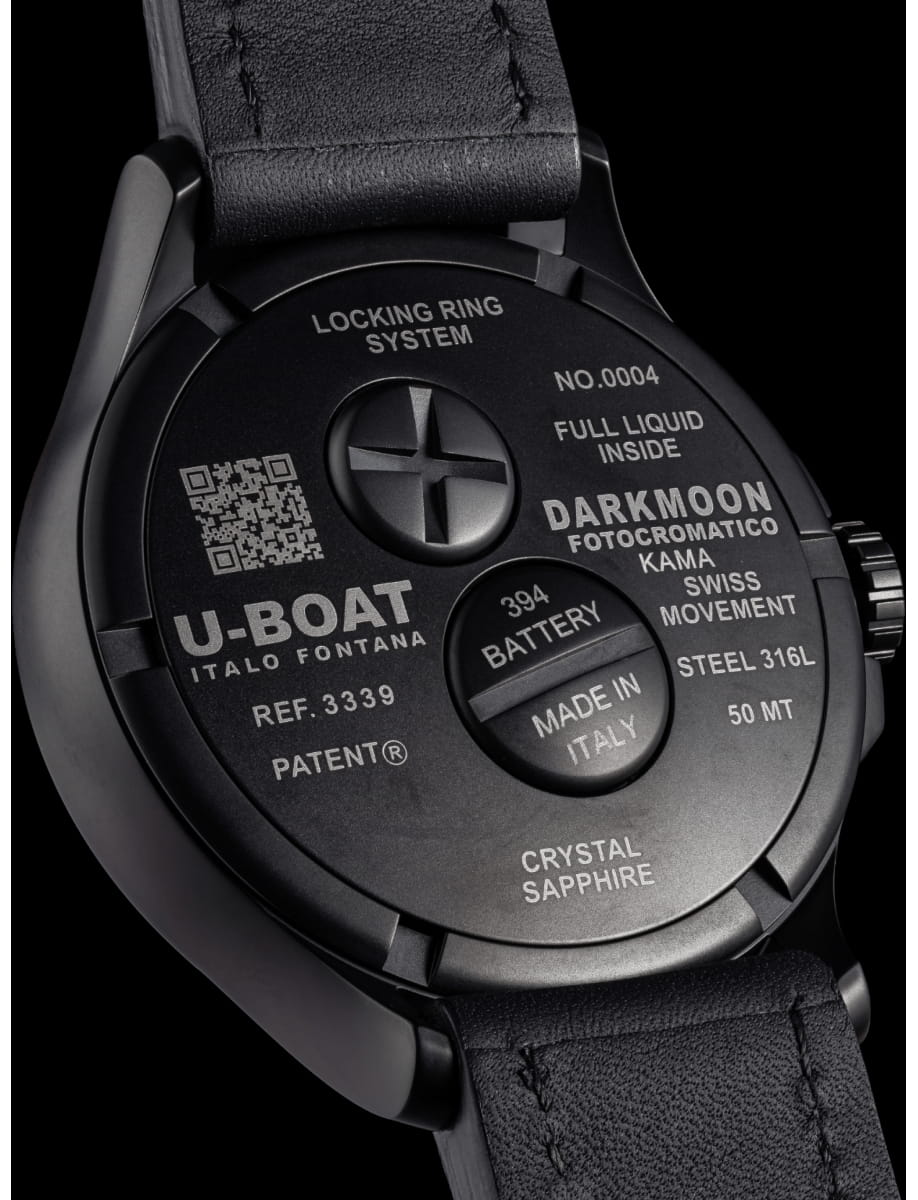 Back of a black wristwatch with engraved text: U-BOAT Italo Fontana, locking ring system, made in Italy, 394 battery, crystal sapphire, Swiss movement, metal case and leather strap visualized against a dark background.