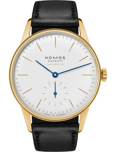 Gold wristwatch with white dial, blue hands, and black leather strap (Nomos Glashütte neomatik, Made in Germany).