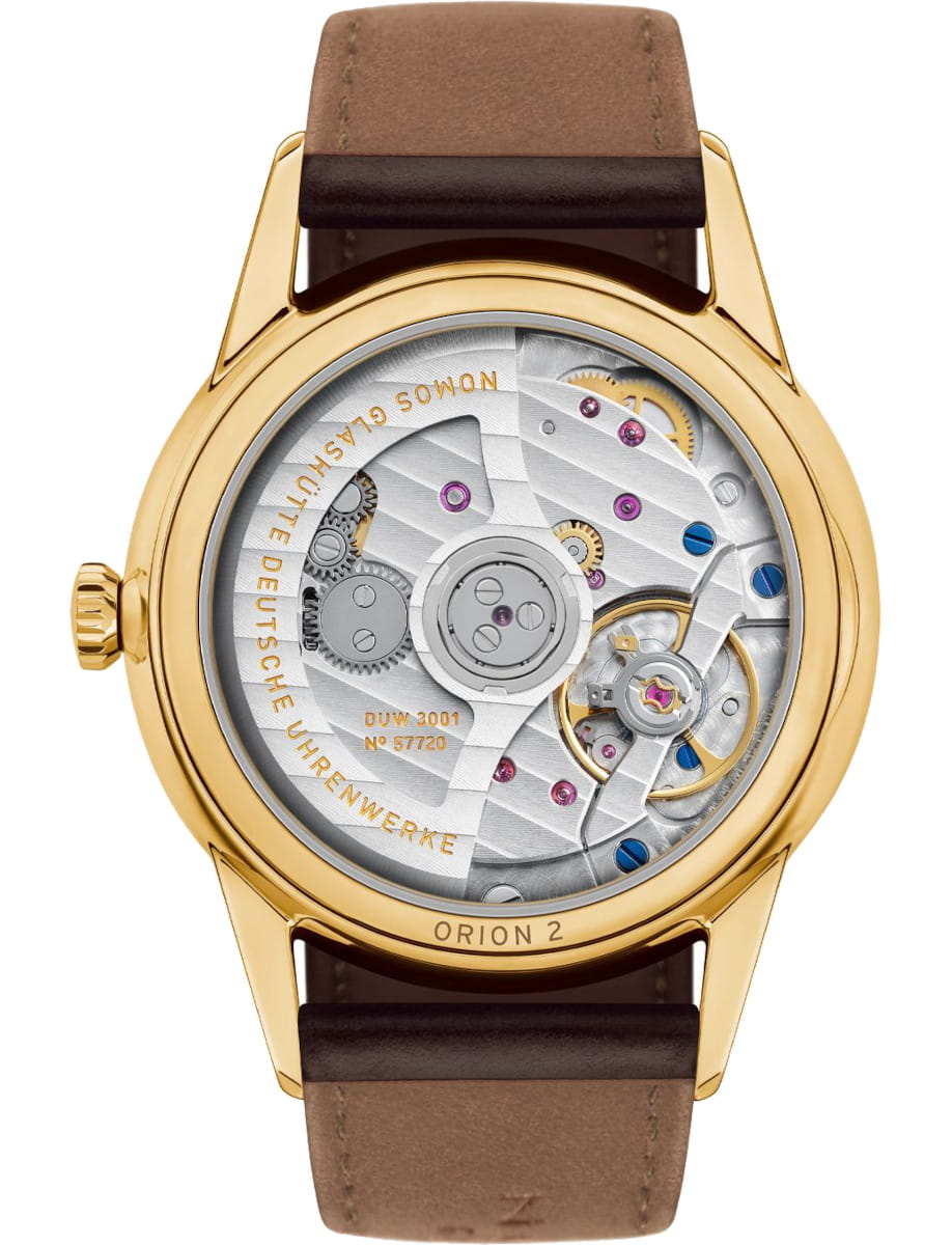 Gold wristwatch with a transparent caseback showing its mechanical movement and gears inside, leather strap visible at top and bottom.