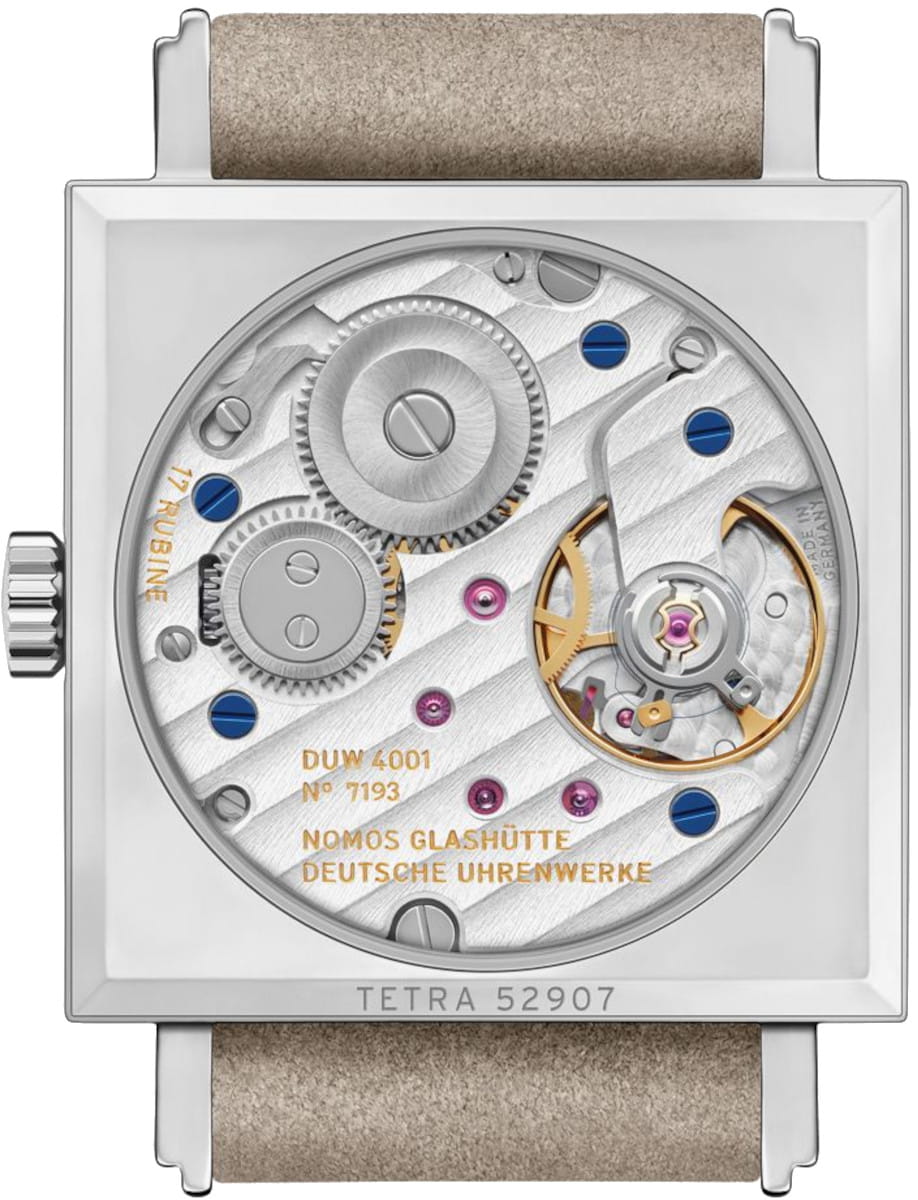 Rectangular wristwatch with an exposed mechanical movement, gears and balance wheel visible through a transparent back, beige strap.