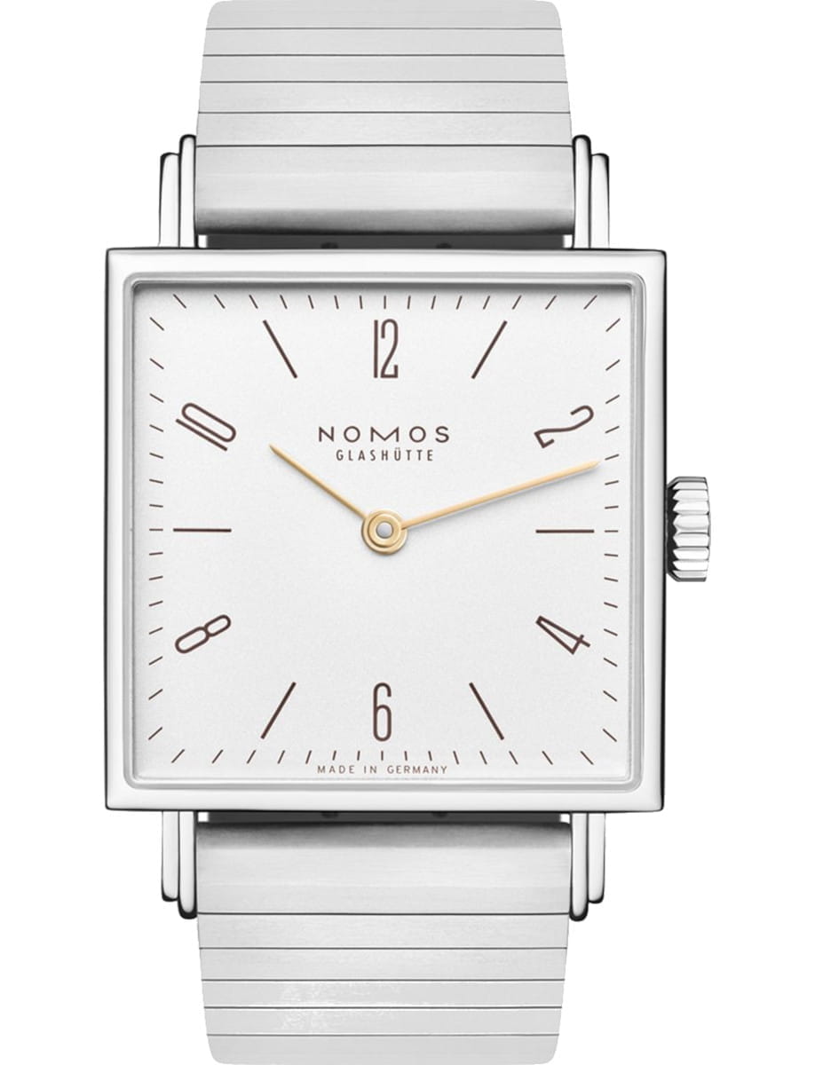 Square silver wristwatch with a white dial, gold hands, and a metal link band; Nomos Glashütte on the face.