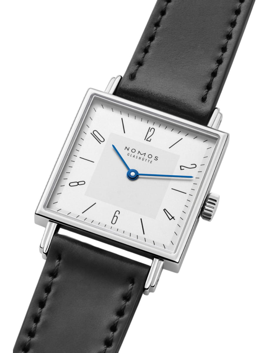 Square wristwatch with white dial, blue hands, and black leather strap.