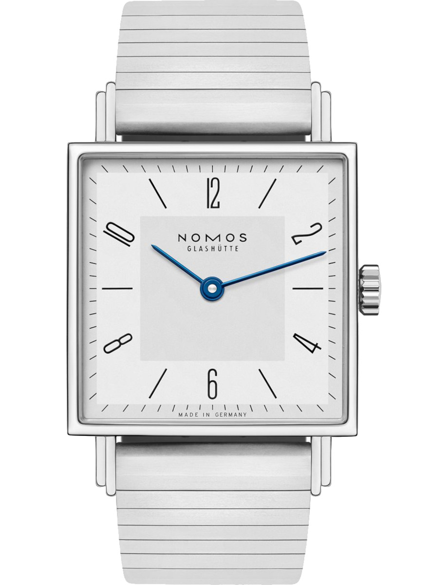 Square silver wristwatch with a white dial, blue hands, and a metal bracelet; Nomos Glashütte, Made in Germany.