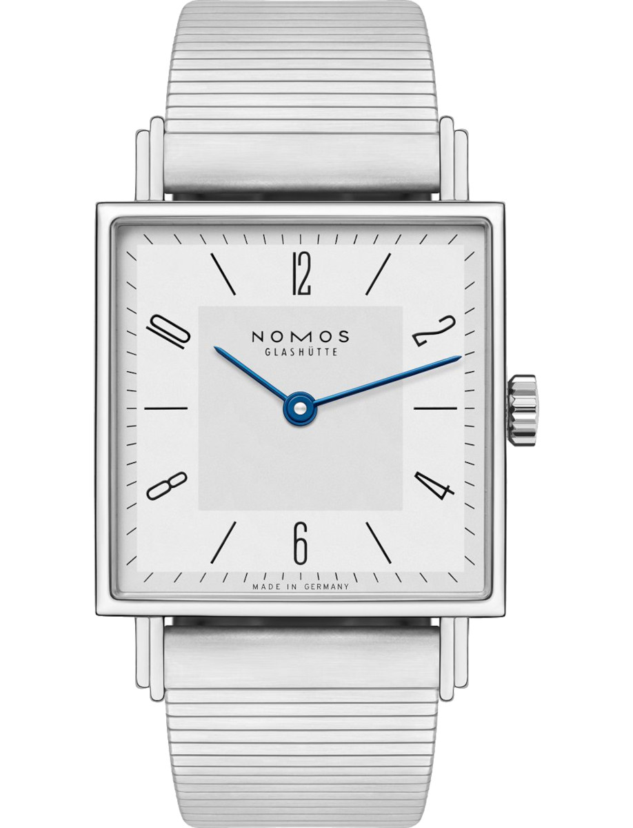 Square silver wristwatch with blue hands and a metal expansion band, NOMOS Glashütte, Made in Germany.
