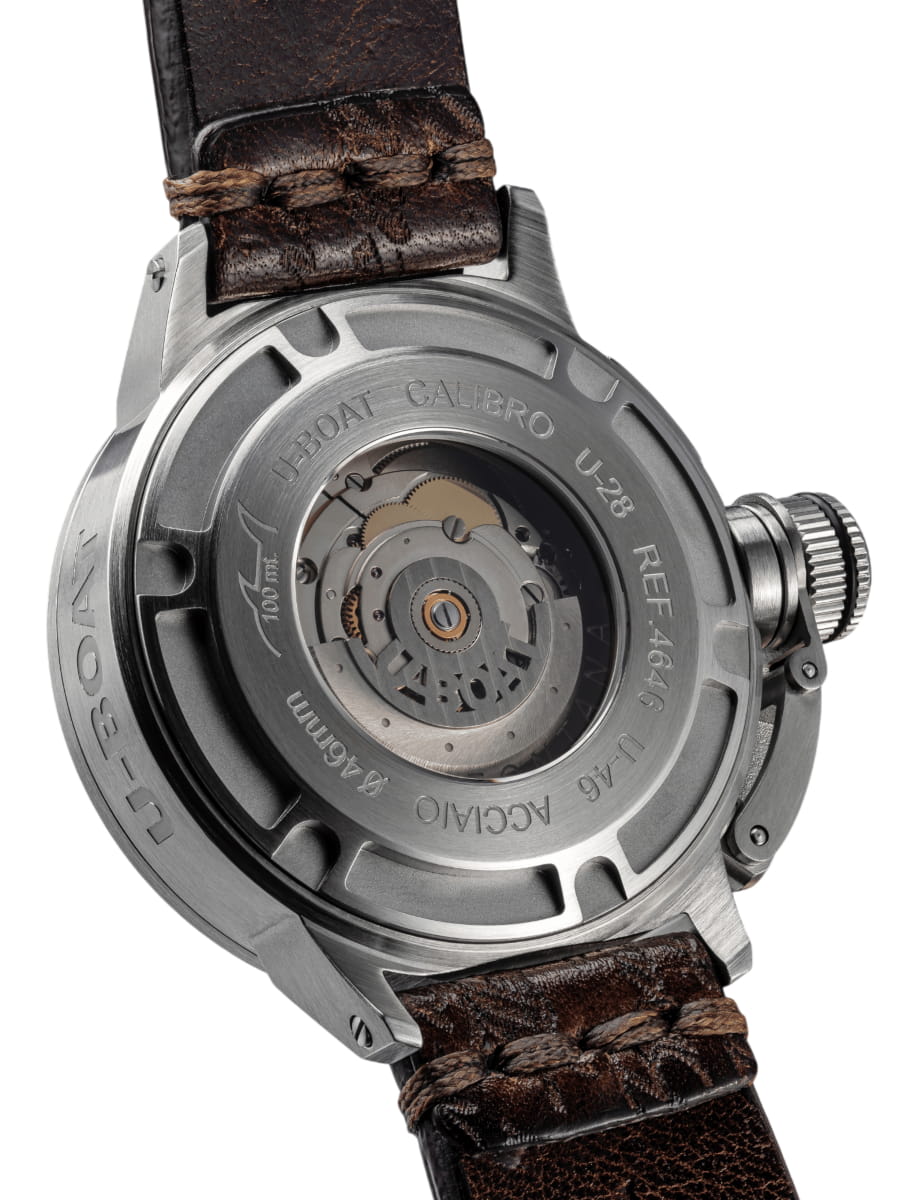 Stainless steel watch back with visible mechanical movement and brown leather strap