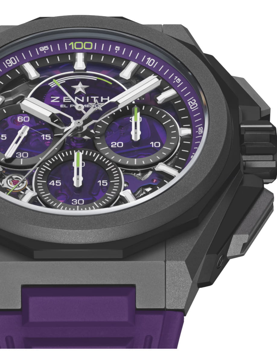 Luxury wristwatch close-up: titanium case, violet dial accents, and purple rubber strap with multiple subdials (Zenith El Primero).