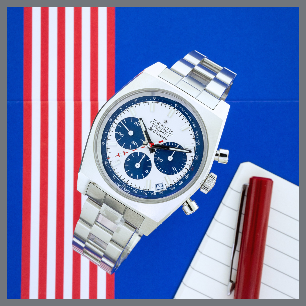 A red white and blue zenith chronograph watch on a blue background