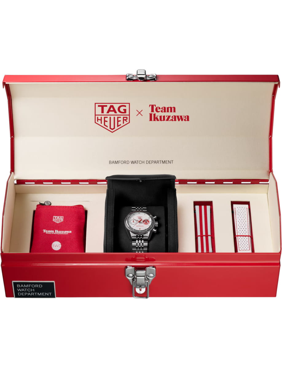Open red presentation box showing a TAG Heuer x Team Ikuzawa watch set with accessories inside: watch, strap, and pouch.