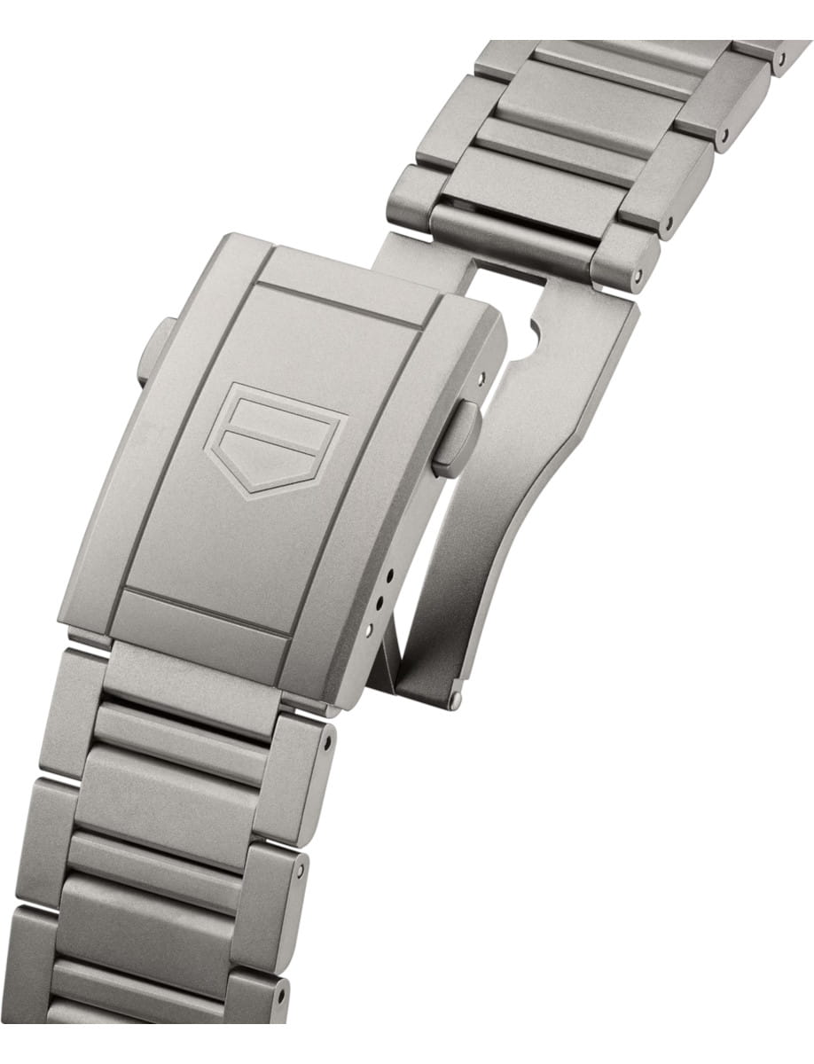 Close-up of a titanium watch bracelet featuring a fold-over deployment clasp.
