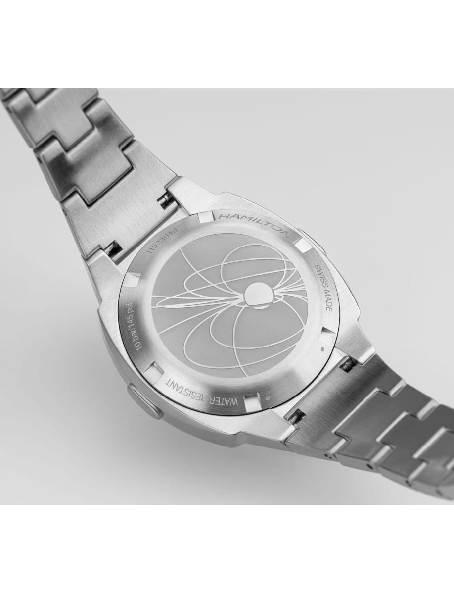 Stainless steel wristwatch with a round case back featuring an abstract circular engraving and brand text.