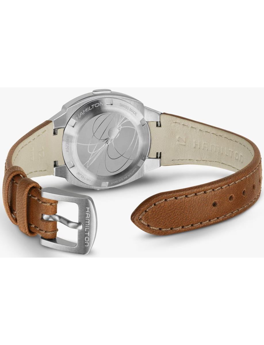 Rear view of a Hamilton wristwatch with a light tan leather strap and a brushed metal case back, showing engravings on the back plate.