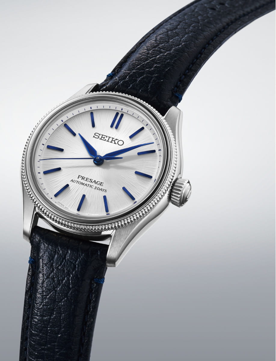 Side view of Seiko Presage wristwatch with stainless steel case, white dial, and cow leather strap.