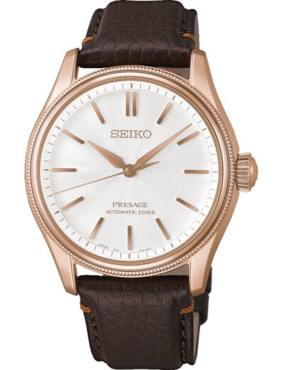 Pink-gold-colored stainless steel Seiko wristwatch with white dial and brown leather strap, classic analog design.