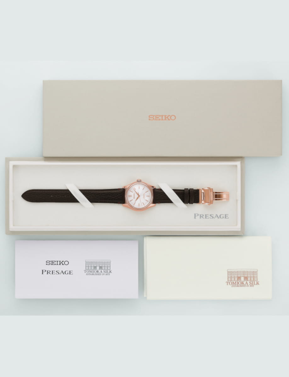 Pink gold colored stainless steel Seiko Presage wristwatch with a brown leather strap in its white presentation box.
