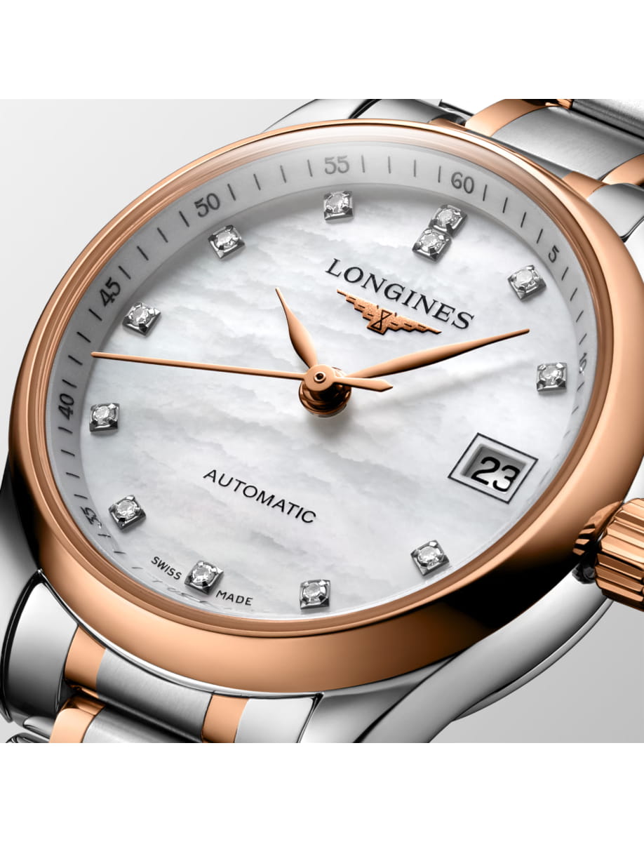 Close-up of a two-tone Longines automatic wristwatch with diamond hour markers and date display at 3 o'clock.