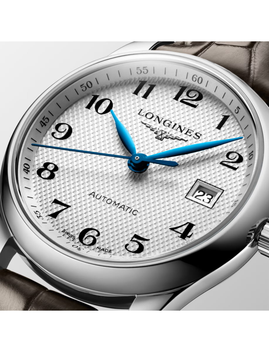 Close-up of a silver Longines wristwatch with a textured white dial, blue hands, and a date window