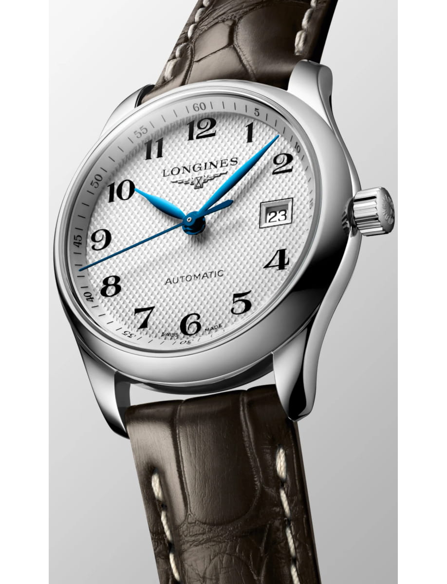 Close-up of a stainless steel Longines wristwatch with a white textured dial, blue hands, and a brown leather strap showing the date.