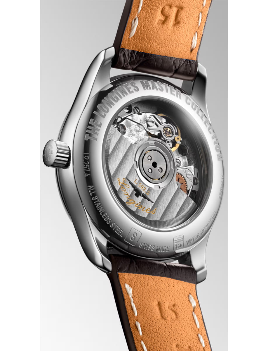 Close-up of a luxury wristwatch showing its transparent case back and visible mechanical movement with a brown leather strap.